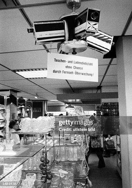 Economy, retailing, shoplifting, prevention, deterrence, observation camera in a store, indicating label -