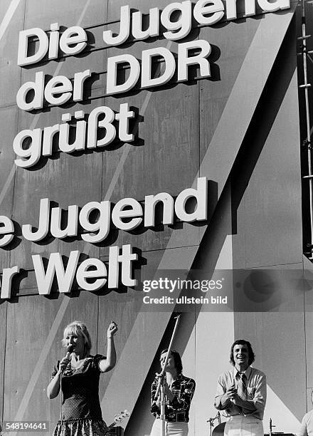 Weltjugendfestspiele / Weltfestspiele der Jugend und Studenten in Berlin / DDR vom 28.07. - : Musikgruppe vor einer Plakatwand 'Jugend der DDR grüsst...