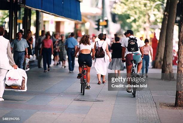 Fehlverhalten im Straßenverkehr: zwei Fahrradfahrer fahren nebeneinander auf dem Gehweg links der Straße - 1995