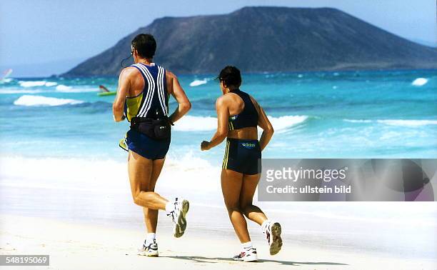Mann und Frau joggen am Strand - 2000
