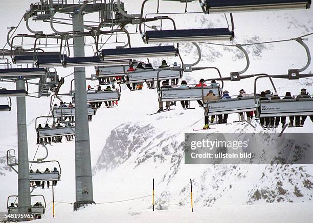 Österreich, Stubaital - Skifahrer in einem Sessellift