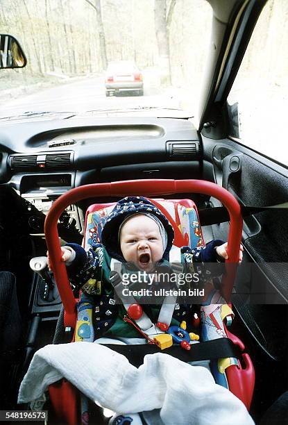 Säugling im Kindersitz auf dem Beifahrersitz eines PKW - 2000