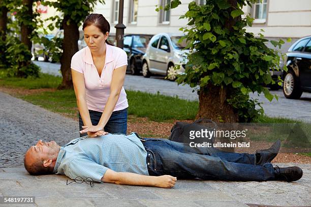 Symbolic photo heart attack, woman is giving first aid -
