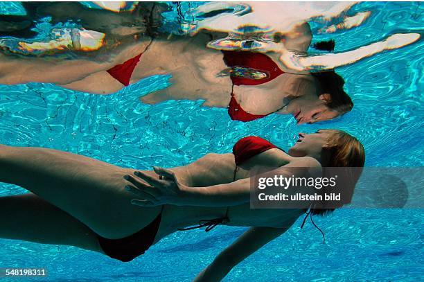 Junge Frau im Bikini schwimmt unter Wasser