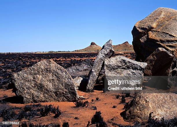 Australia - Roebourne: Burnt Landscape and rocks in the foreground north of Roebourne, Chichester Range, Northwest Australia,