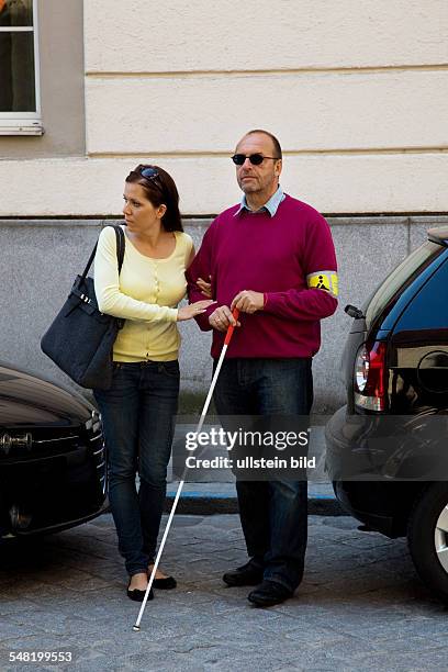 Symbolic photo blind person, young woman is accompanying a blind man -