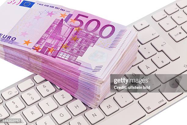 Pile of 500 Euro banknotes on a computer keyboard