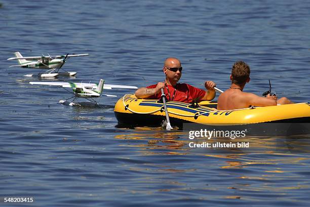 Germany Berlin Treptow - men in a rubber boat and model airplanes on the water -