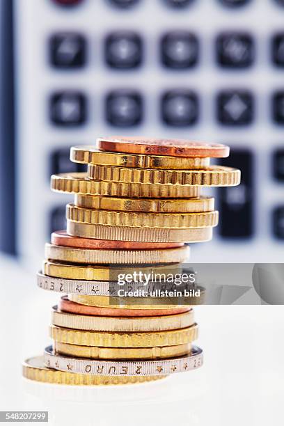 Pile of Euro coins in front of a calculator