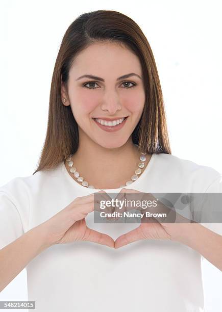 young woman making heart sign - truehearts stock pictures, royalty-free photos & images