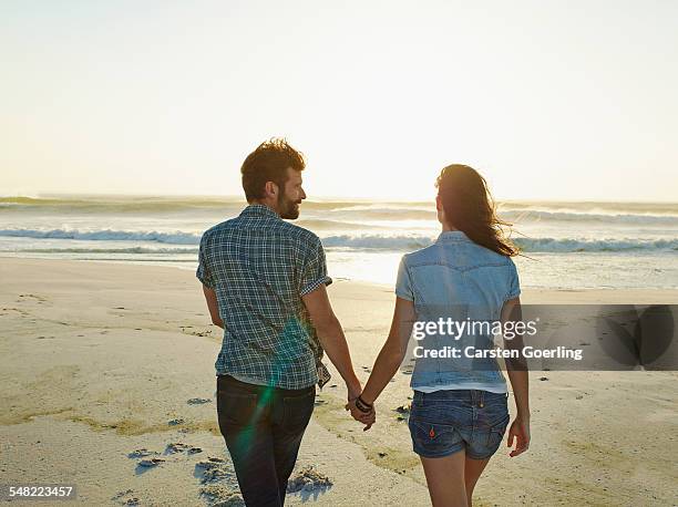 young couple on a roadtrip - couple walking on beach foto e immagini stock