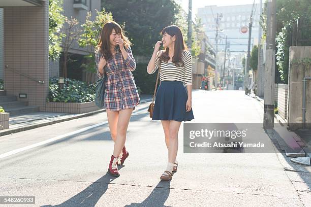 japanese women walking on street,smiling - japanese short skirts stockfoto's en -beelden