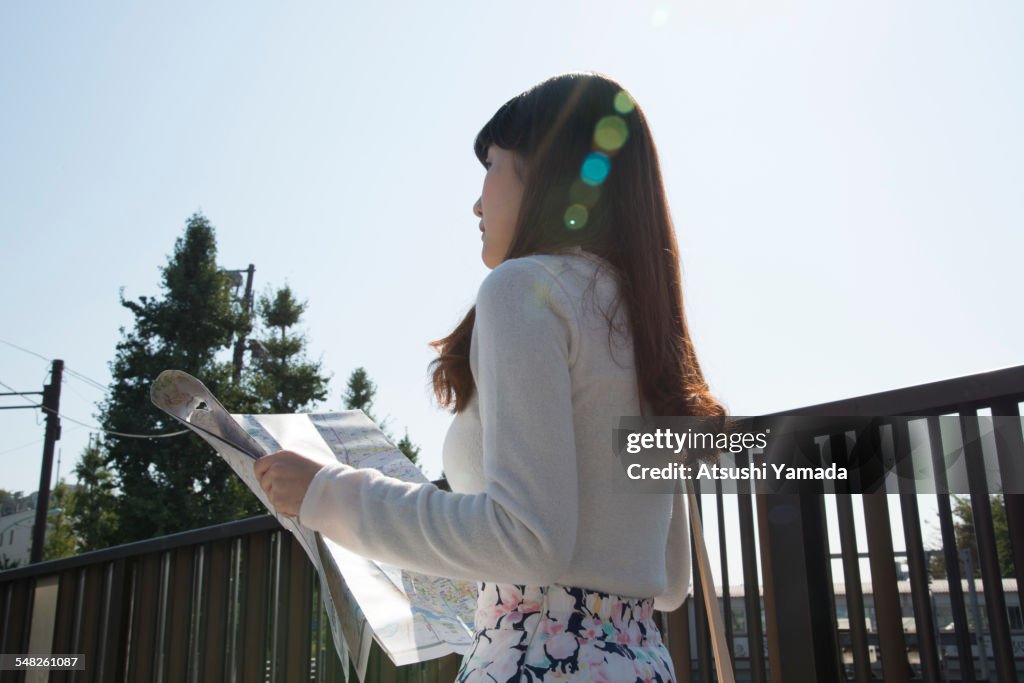Japanese woman holding map on street