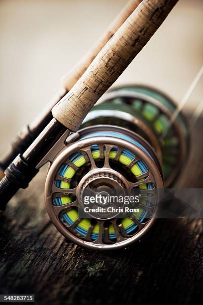 a short focus shot of fly reel resting on wooden plank - fishing reel stock pictures, royalty-free photos & images