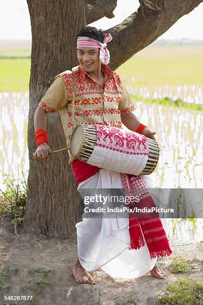 portrait of bihu man playing on a dhol - bihu fotografías e imágenes de stock