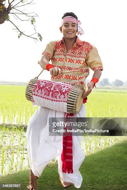portrait of bihu man playing on a dhol - bihu stock pictures, royalty-free photos & images