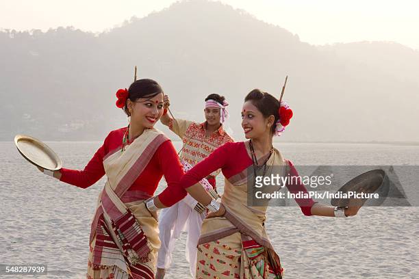 bihu women dancing with brass plates - bihu stock pictures, royalty-free photos & images