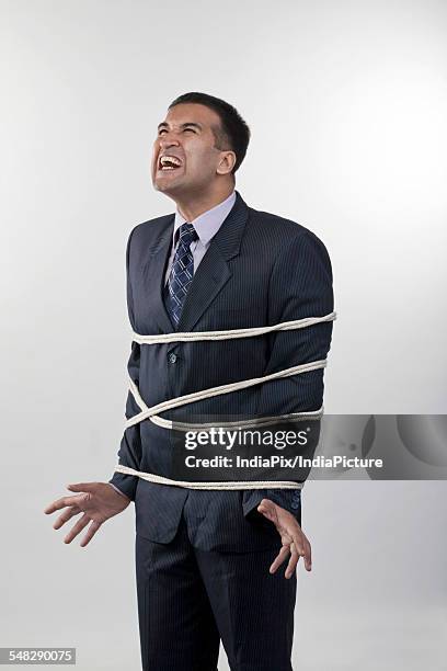 businessman tied up with rope - restraining fotografías e imágenes de stock