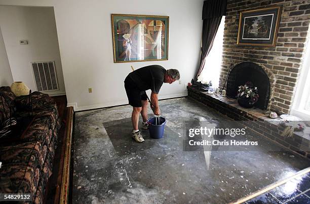 Larry Armstrong mops up the floor of his brother's apartment September 5, 2005 in Metairie, Louisiana. A week after Hurricane Katrina hit, residents...