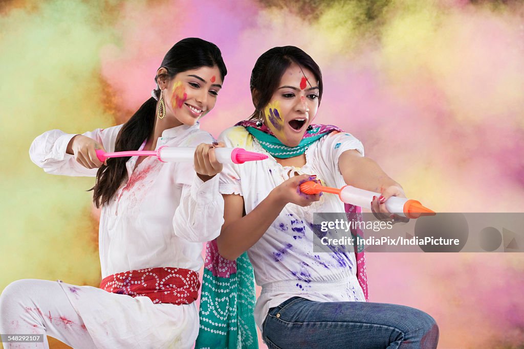 Women playing holi with pichkaris