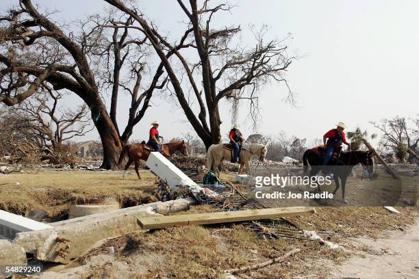 Bexar County Mounted Patrol search and rescue team members ride their horses through the rubble of destroyed homes looking for bodies of people after...