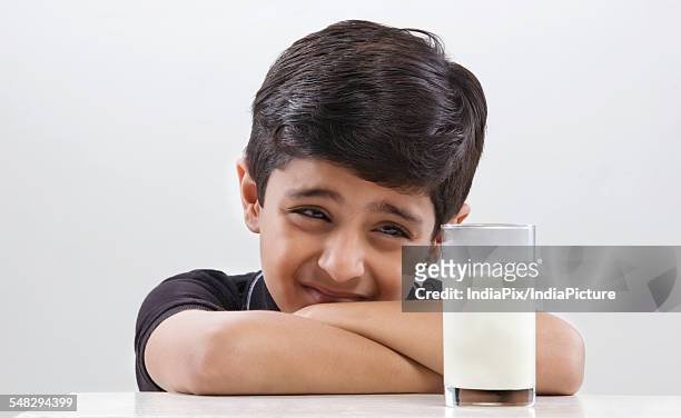 young boy looking at a glass of milk - hate stock-fotos und bilder