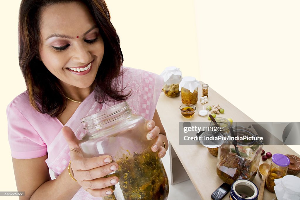 Woman looking into a jar of pickle