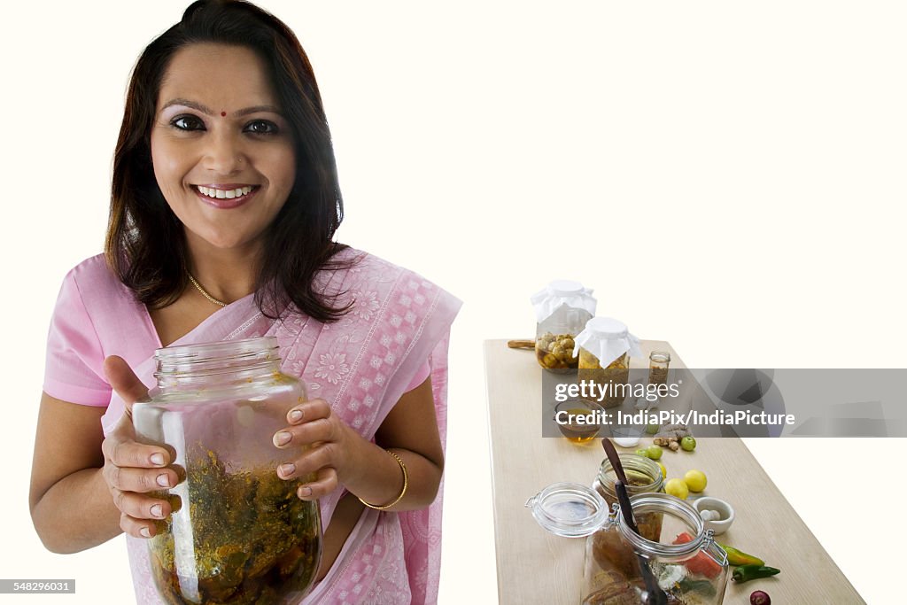 Portrait of a woman holding a jar of pickle