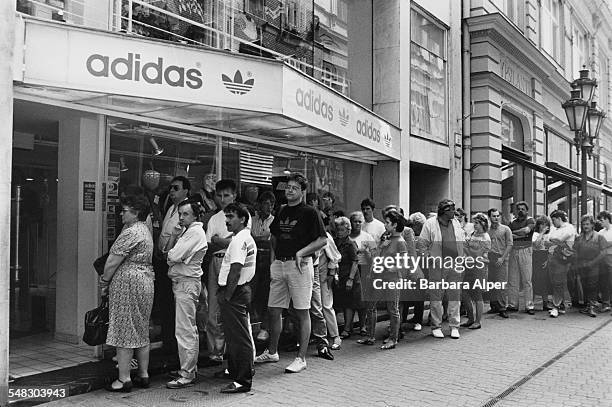 People queuing outside a shop selling Adidas shoes on Váci Utca in Budapest, Hungary, 22nd May 1990.