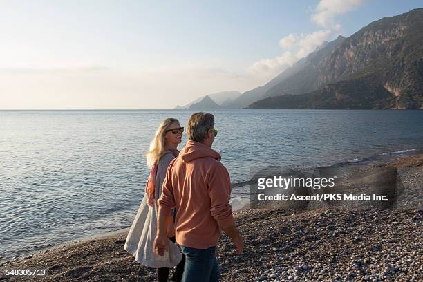 couple walk along beach in early light, talking - antalya province stock pictures, royalty-free photos & images