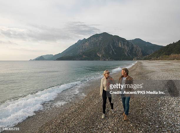 couple walk along beach in early light, talking - antalya stock pictures, royalty-free photos & images