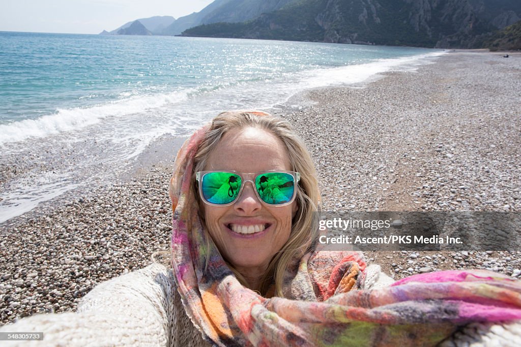 Woman takes selfie portrait on empty beach