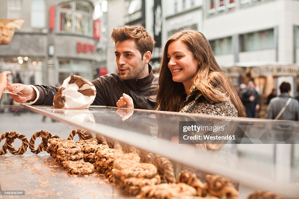 Germany, Cologne, young couple in the city at bakery