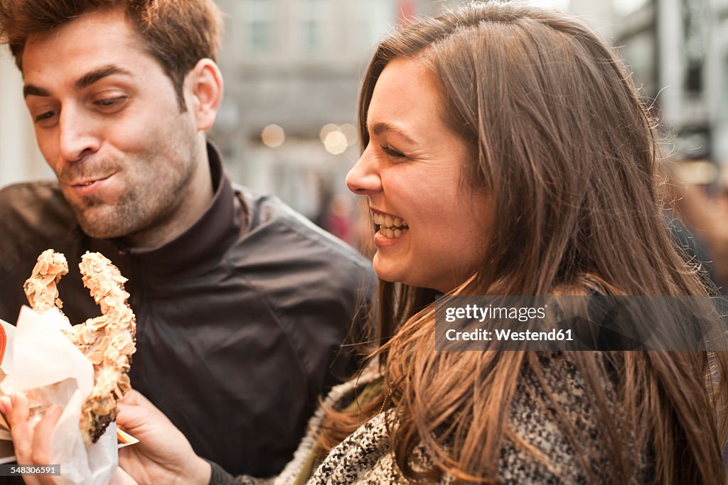 Germany, Cologne, young couple with pastry