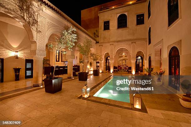 morocco, fes, hotel riad fes, courtyard with lightened pool by night - fountain courtyard fotografías e imágenes de stock