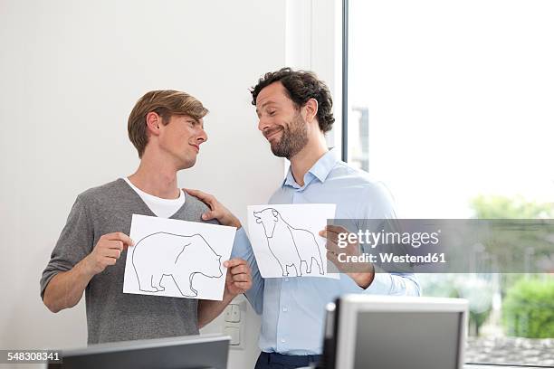 two businessmen holding papers with bull and bear figure - pessimism stock pictures, royalty-free photos & images