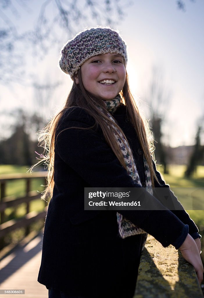 Portrait of smiling girl wearing wool cap and scarf