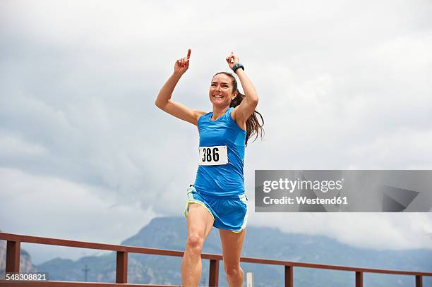 italy, trentino, woman winning a running competition near lake garda - athleticism stockfoto's en -beelden