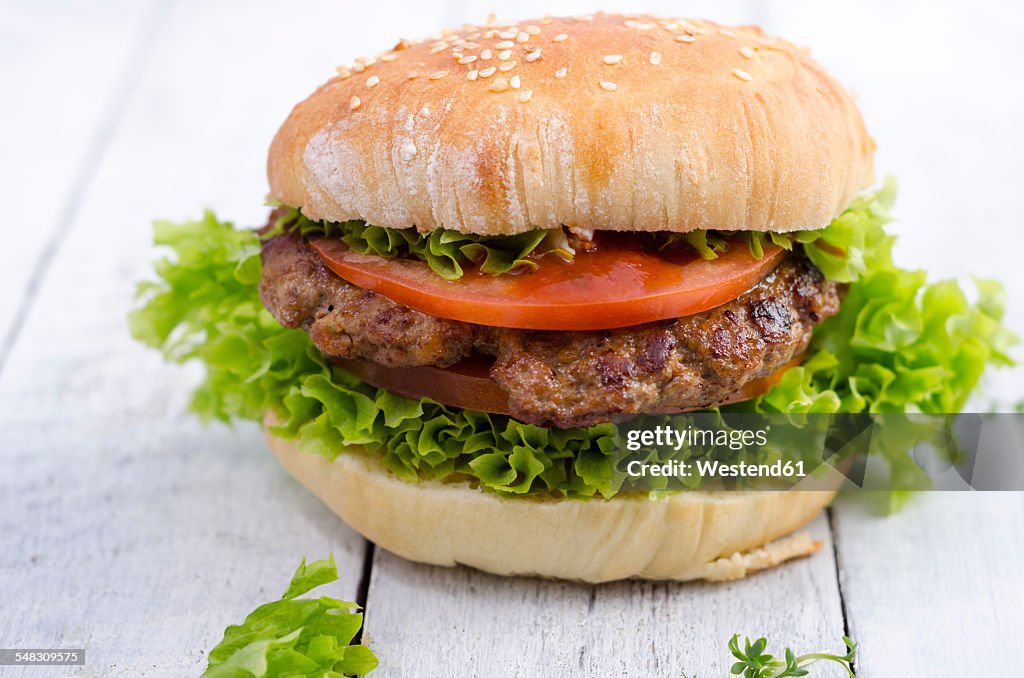 Homemade hamburger with minced beef and lettuce on sesame roll