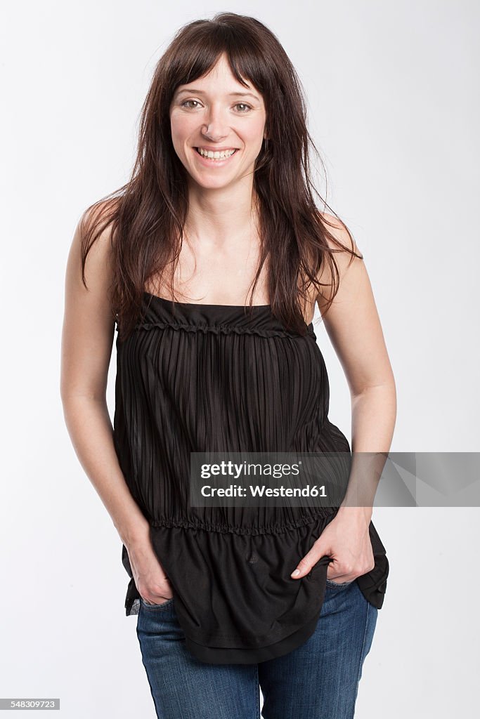 Portrait of smiling woman with hands in her pockets