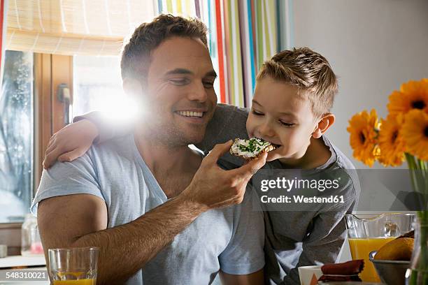 father and son having breakfast together - breakfast family stock-fotos und bilder