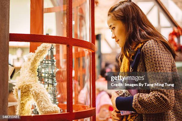 young lady looking at christmas window display - christmas celebrations in china stock pictures, royalty-free photos & images