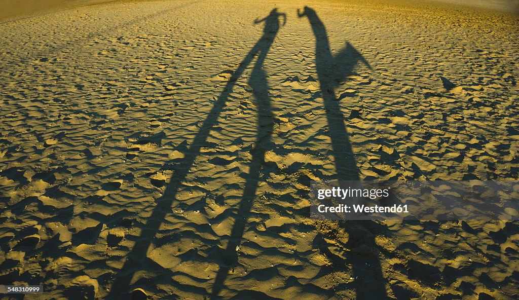 Spain, Valencia, shadow play of two persong on the beach