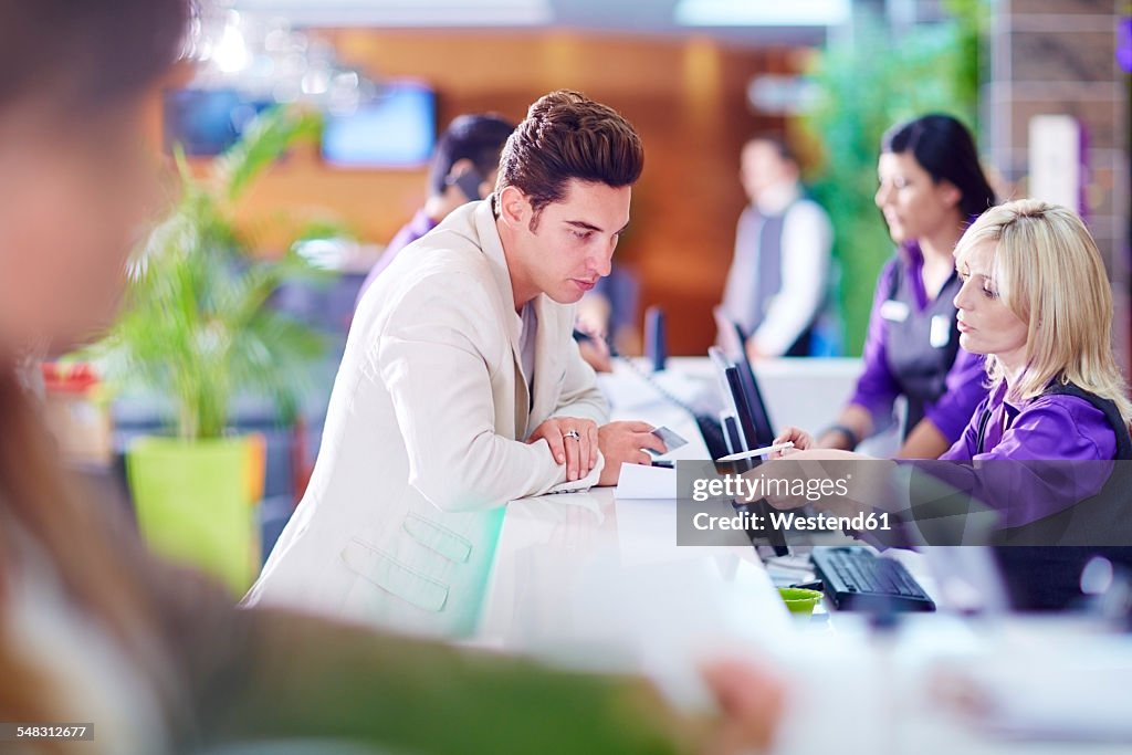 Businessman registering at hotel reception