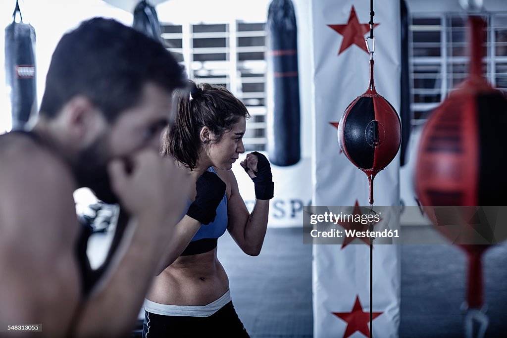 Man and woman exercising with punchingballs