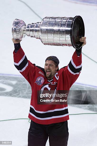 Scott Stevens of the New Jersey Devils hoists the Stanley Cup trophy after winning Game 6 of the NHL Stanley Cup finals over the Dallas Stars at...