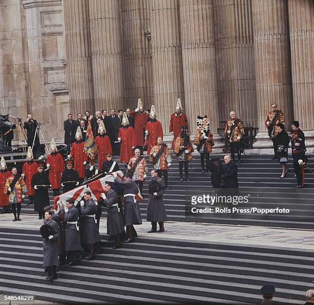 View of members of the British armed services carrying the coffin of Sir Winston Churchill draped in the Union flag down the steps of St Paul's...