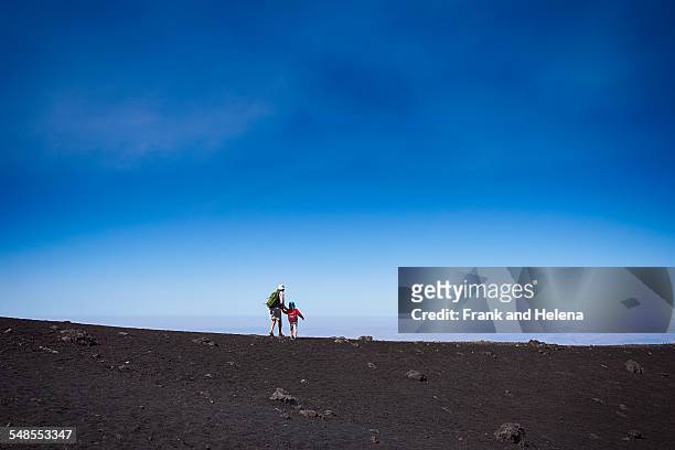distant view of senior woman and grandson on mount etna, catania, sicily, italy - frank catania ストックフォトと画像