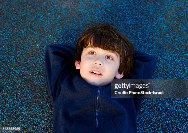 cute boy lying on back gazing upward - boy thinking stock pictures, royalty-free photos & images