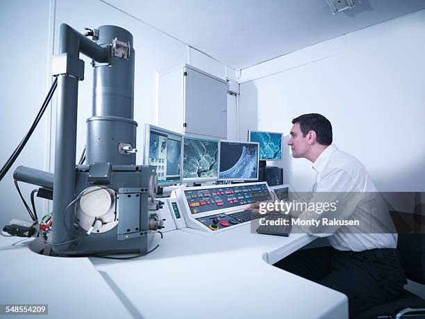 metallurgist working with electron microscope in automotive test facility - elektronenmicroscopisch-beeld stockfoto's en -beelden